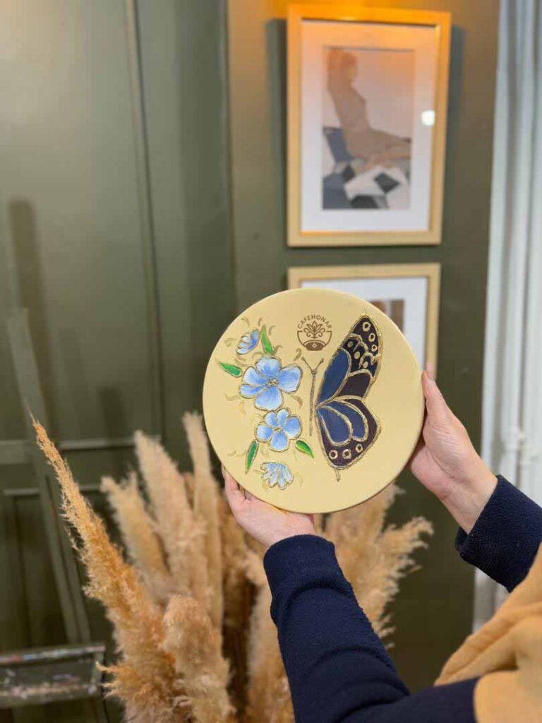 نقاشی پروانه و گل روی بشقاب سفالی در کافه هنر کرج